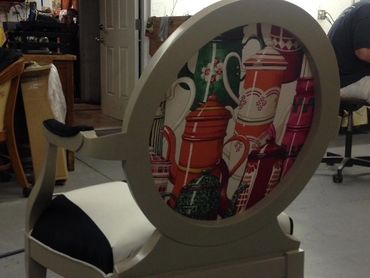 Chair with a round backrest featuring colorful teapot designs.
