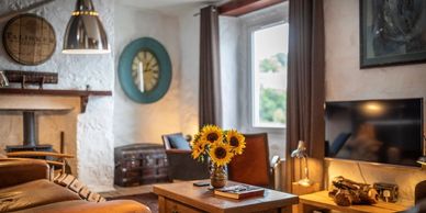 Cozy living room with sunflowers on a wooden coffee table and warm lighting.