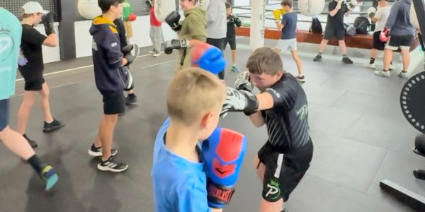 Kids practicing boxing in a gym.