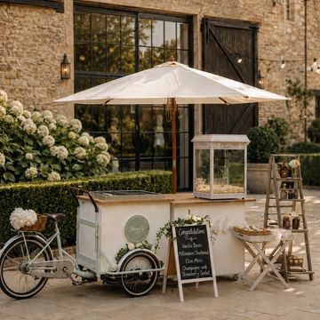 Vintage outdoor popcorn cart with umbrella and decorations.