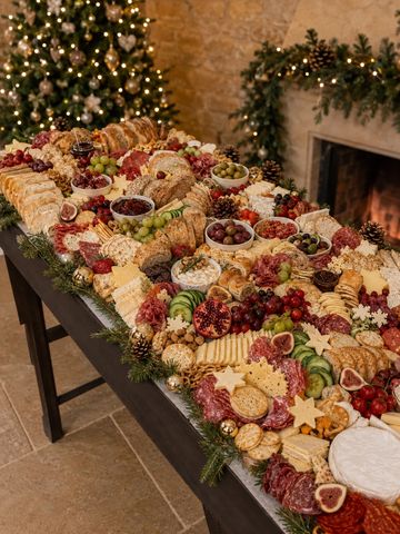 Festive holiday charcuterie board with assorted meats, cheeses, fruits, and crackers.