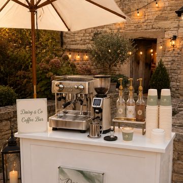 Outdoor coffee bar setup at dusk with warm lighting.