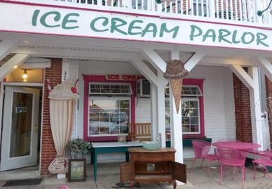 Front view of an ice cream parlor with decorative giant cones.