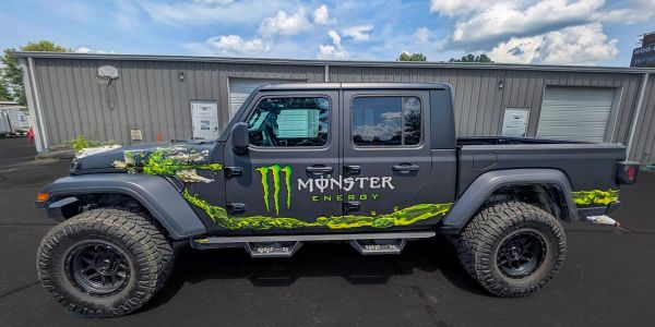 Black Jeep Gladiator with Monster Energy decals.