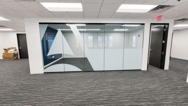 Empty office space with glass walls and logo.