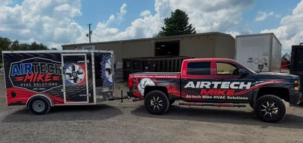 Red and black HVAC service truck with matching trailer.