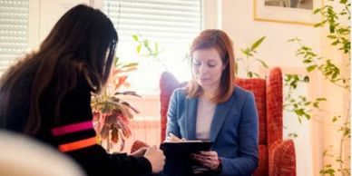 The image is two people talking as part of a simulated appointment between a client and clinician.