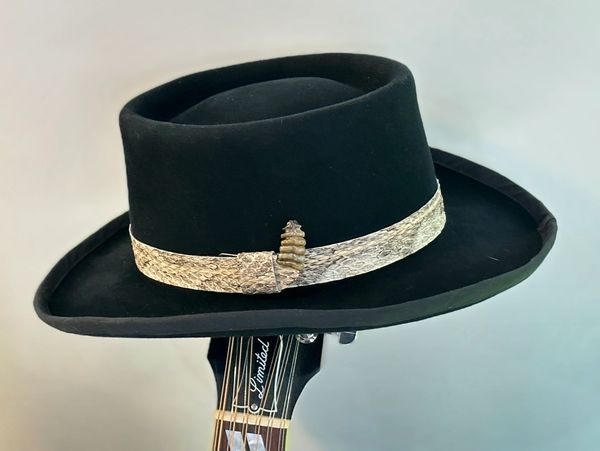 Gambler hat with rattlesnake hat band on a guitar