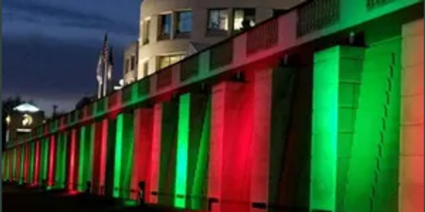 Building illuminated with red and green lights at night.