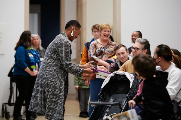 A woman shares a moment with a seated group at an event.