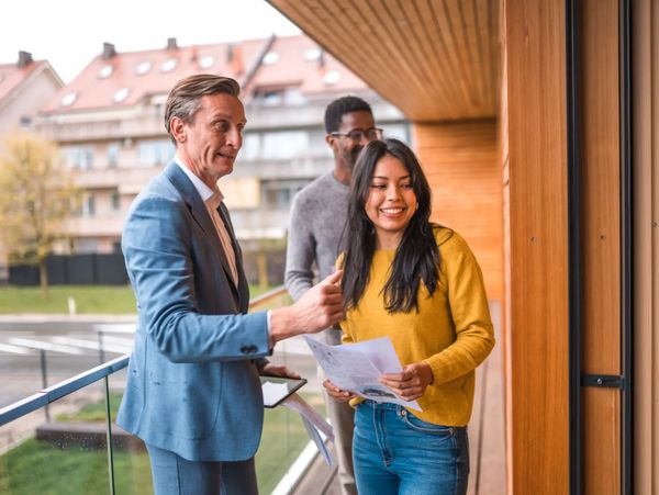 Two people discussing papers on a balcony