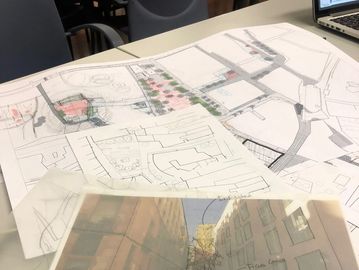 Planos arquitectónicos y bocetos sobre una mesa.