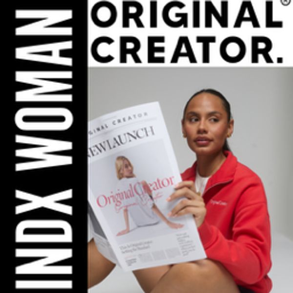 Woman in red holding an Original Creator magazine against a black and white logo background.