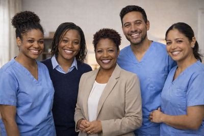 A diverse group of healthcare professionals smiling together indoors.