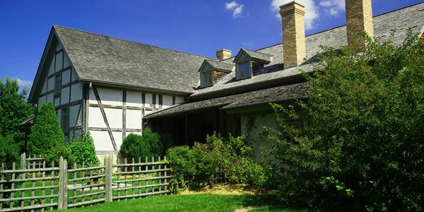 Traditional house with a wooden fence and green lawn.