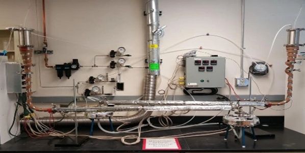 Laboratory setup with multiple gauges, pipes, and control panels for fluid or gas experiments.