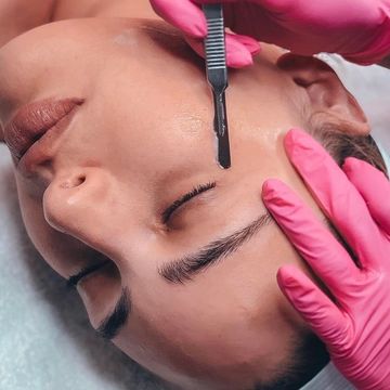 Close-up of eyebrow shaping with a precision tool.