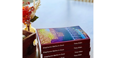 Photos of print copies of "Elephants Bathe in Dust", a novel by Tony Eden.