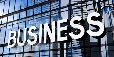 Large 3D BUSINESS sign on a glass office building.