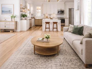Bright, modern open living room and kitchen with neutral tones.