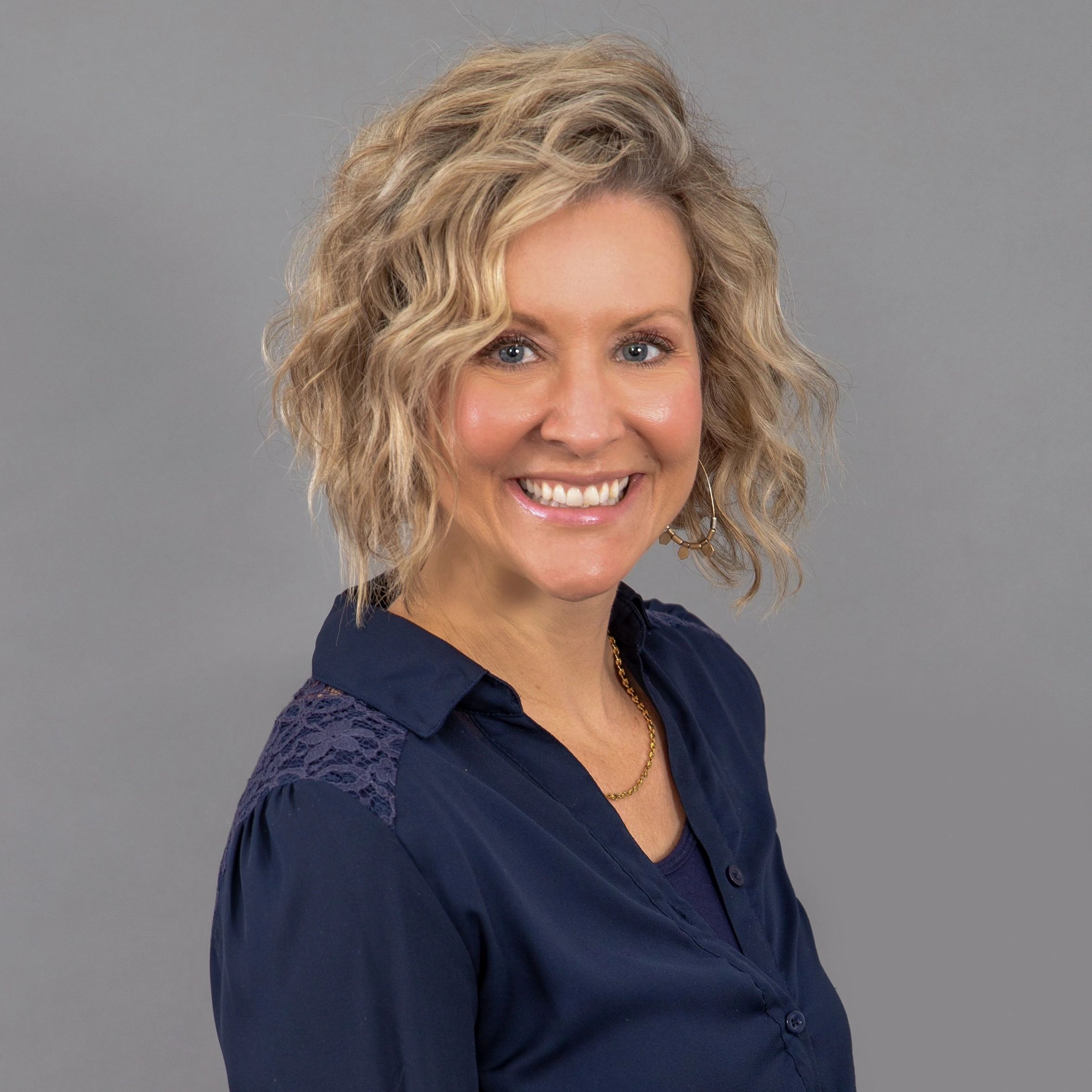 Headshot of Alisha, she is posed in business casual while smiling at the camera.