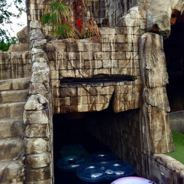 Entrance to a dark water ride with inner tubes.