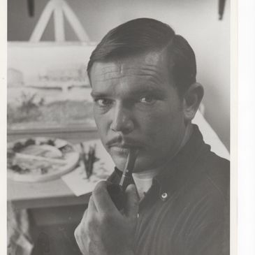 Black and white portrait of a man holding a pipe, with painting supplies in the background.