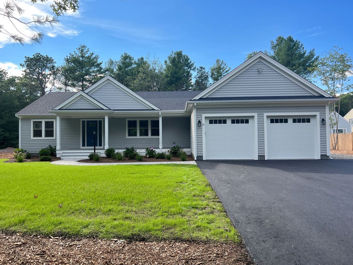 Single-story gray house with two-car garage and green lawn.