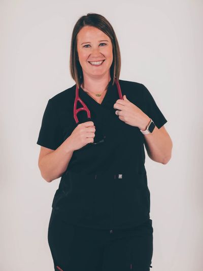Smiling female healthcare professional with a stethoscope around her neck.