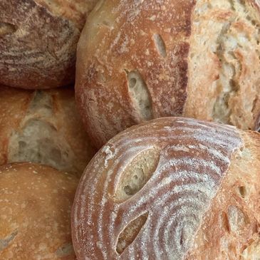 Close-up of artisanal round bread loaves with flour dusting and rustic crusts.