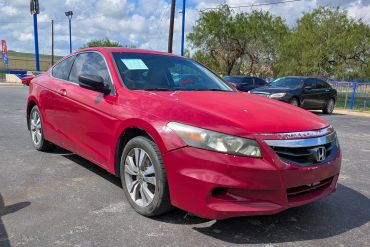 Red Honda coupe parked outdoors on a sunny day.