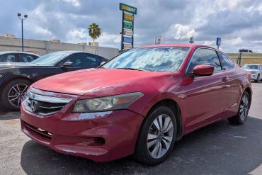Red Honda coupe parked outdoors.