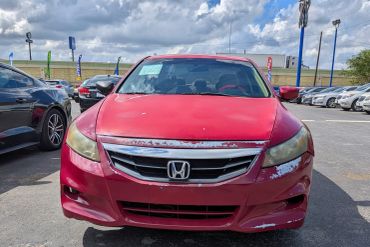 Front view of a red Honda car with damage.