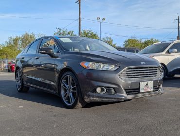 A gray Ford sedan parked outside on a sunny day.