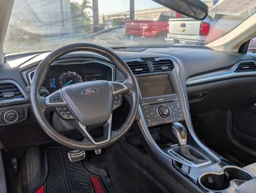 Interior dashboard and steering wheel of a Ford car.