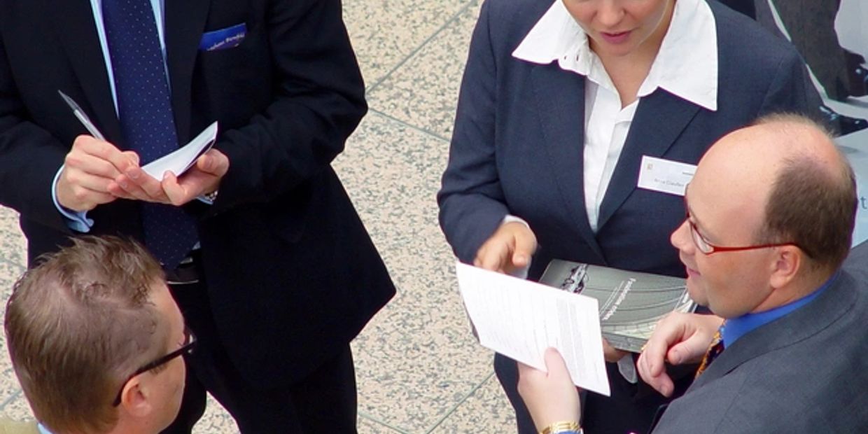 Businesspeople discussing documents in a professional setting.