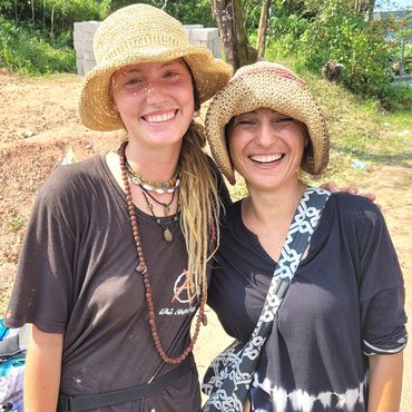 Two attractive women in sun hats smile while posing for a picture