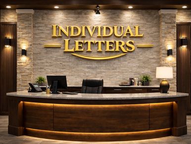 Elegant reception desk with golden "INDIVIDUAL LETTERS" sign on stone wall.