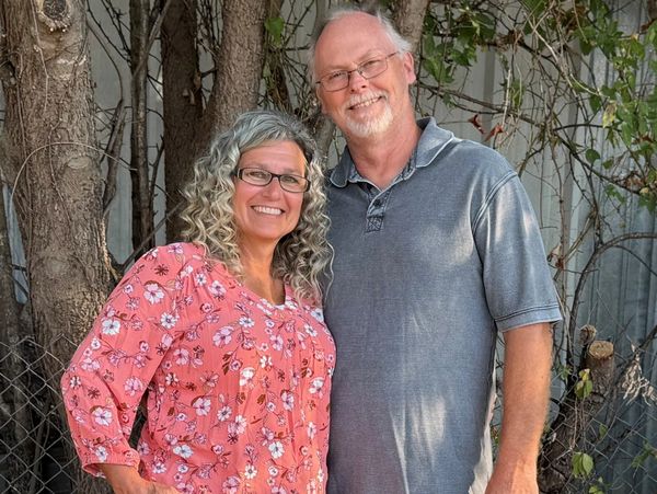 Smiling middle-aged couple posing outdoors.