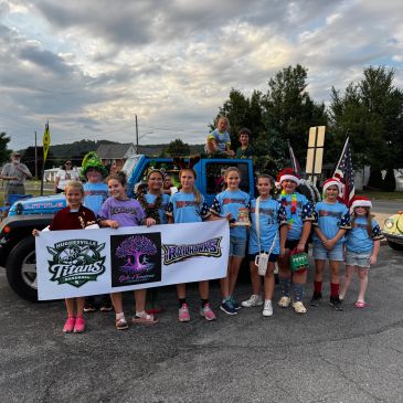 Group of children holding a banner at a parade.