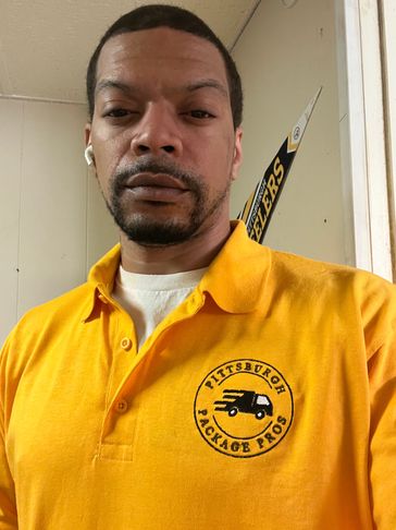 Man wearing a yellow Pittsburgh Package Pros shirt.