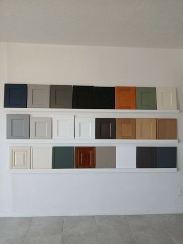 Various cabinet door samples displayed on shelves against a white wall.