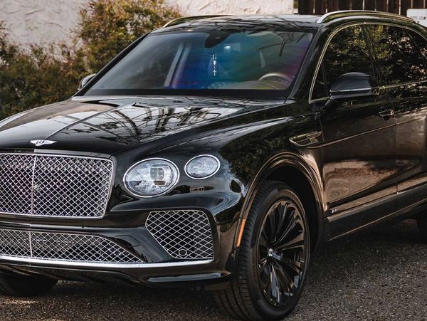 A sleek black Bentley SUV with shiny chrome grille and elegant design.