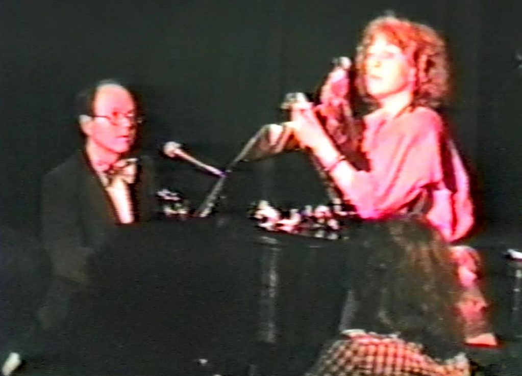Man and woman performing music on stage.