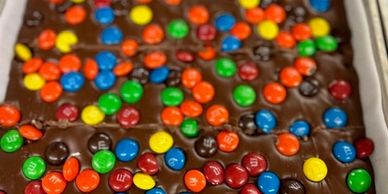 Chocolate bark topped with colorful M&amp;M candies.