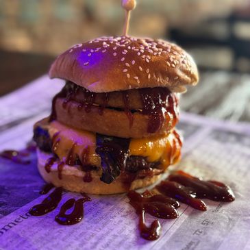 Juicy cheeseburger with barbecue sauce on sesame bun.