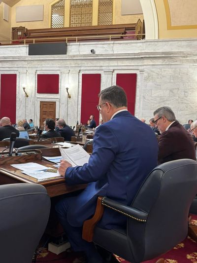 People in a formal government or legislative meeting room.