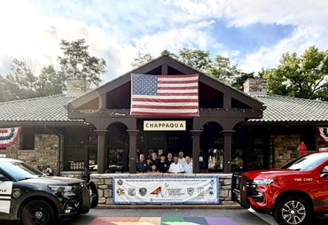 Group photo in front of Chappaqua community center with American flag.
