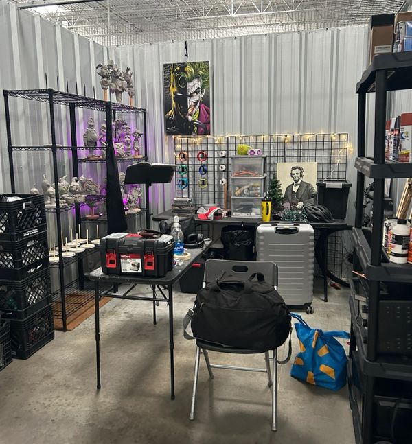 Organized workspace with tools, art, and storage in an industrial room.