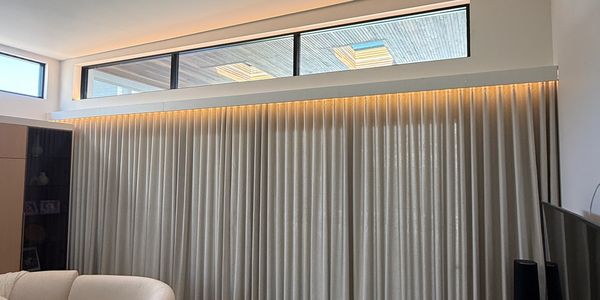 Modern living room with beige curtains and cozy seating.